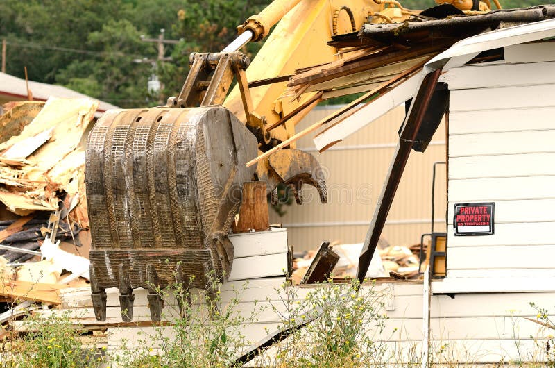 A large track hoe excavator tearing down an old hotel to make way for a new commercial development. Track hoe construction excavator stock images, royalty-free photos and pictures