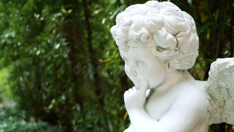 Tracking shot of beautiful green garden with statue of white angel. home decorating and garden design concept