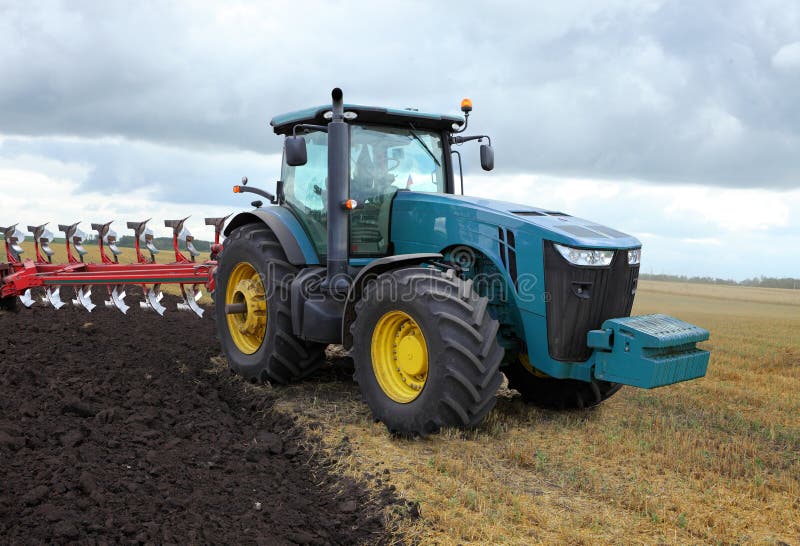 Tracteur avec une charrue image stock. Image du fond - 43346941