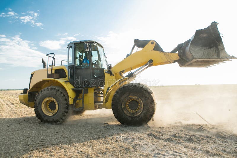 Tracteur jaune sur le lever de soleil d'or, avec un organe fonctionnant augmenté photographie stock Tracteur jaune sur le lever de soleil d'or, avec un organe fonctionnant augmenté photographie stock