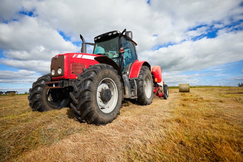 Tractor collecting haystack in the field