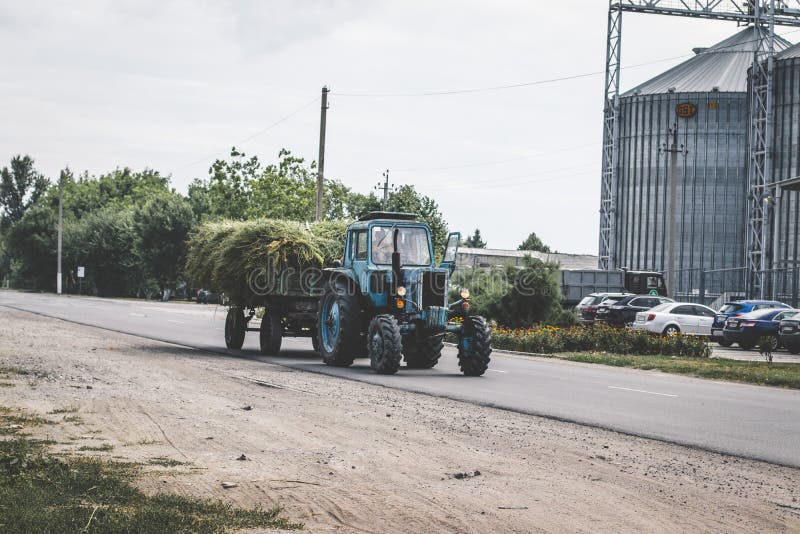 Tractor con vagón de heno. Tractor tirando de un remolque con heno a través de un puente foto de archivo libre de regalías Tractor con vagón de heno. Tractor tirando de un remolque con heno a través de un puente foto de archivo libre de regalías