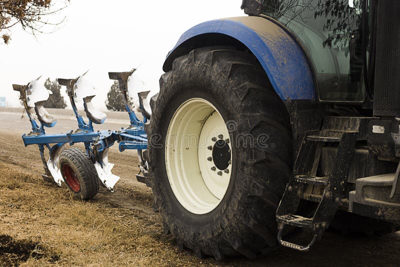 Tractor. Cropped image of modern farm equipment in field