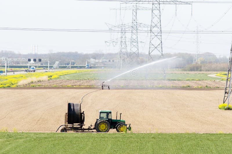 Tractor with irrigation equipment watering crops