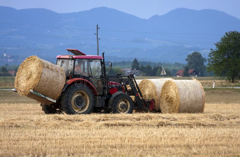 Tractor moving bales