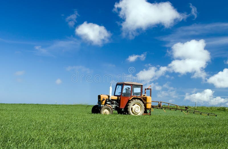 Tractor spraying green field royalty free stock photo