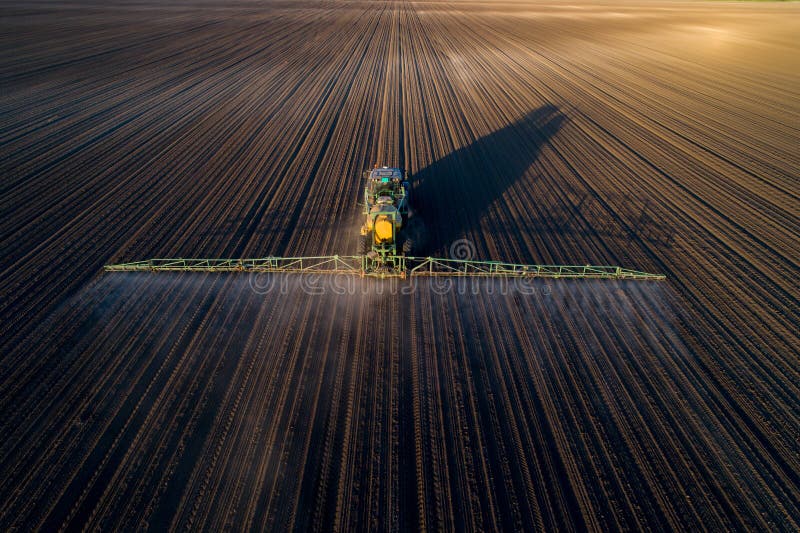 Tractor spraying soil in field