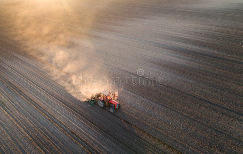 Tractor working in field in spring stock photo