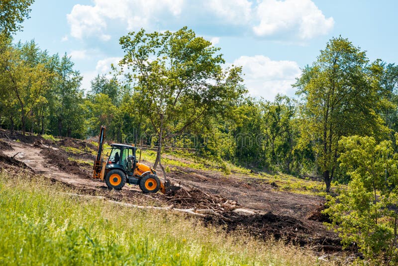 Tractor Works on Landscaping, Tree Branches and Debris Stock Photo
