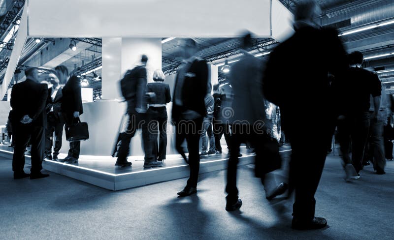 Blurred visitors at a tradeshow rushing between tradeshow booths. ideal for websites and magazines layouts. Blurred visitors at a tradeshow rushing between tradeshow booths. ideal for websites and magazines layouts