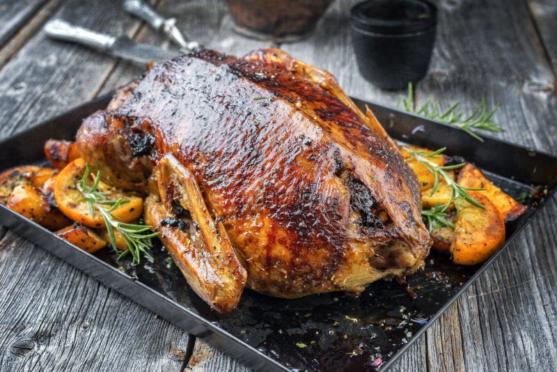 Traditional American Thanksgiving roasted turkey with fruits and potatoes on a board