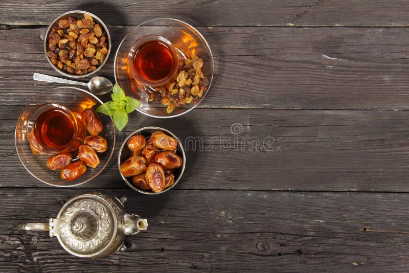 Traditional Arabic, Turkish Ramadan tea with dry dates and raisins on a wooden black table. Ramadan. Turkish fresh tea with dates. stock photography Traditional Arabic, Turkish Ramadan tea with dry dates and raisins on a wooden black table. Ramadan. Turkish fresh tea with dates. stock photography
