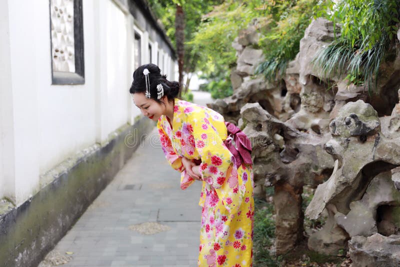 Traditional Asian Japanese woman bride Geisha wearing kimono play in a graden