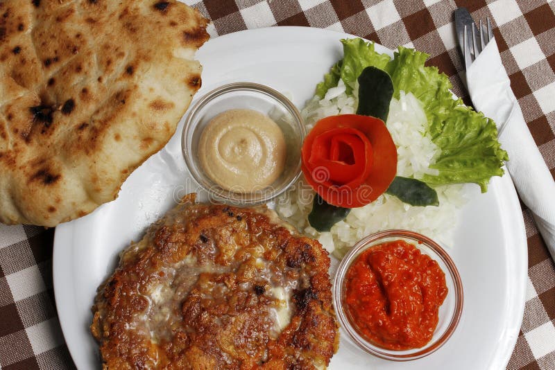 Traditional Balkan pljeskavica with cheese grilled meat with lepinja bread