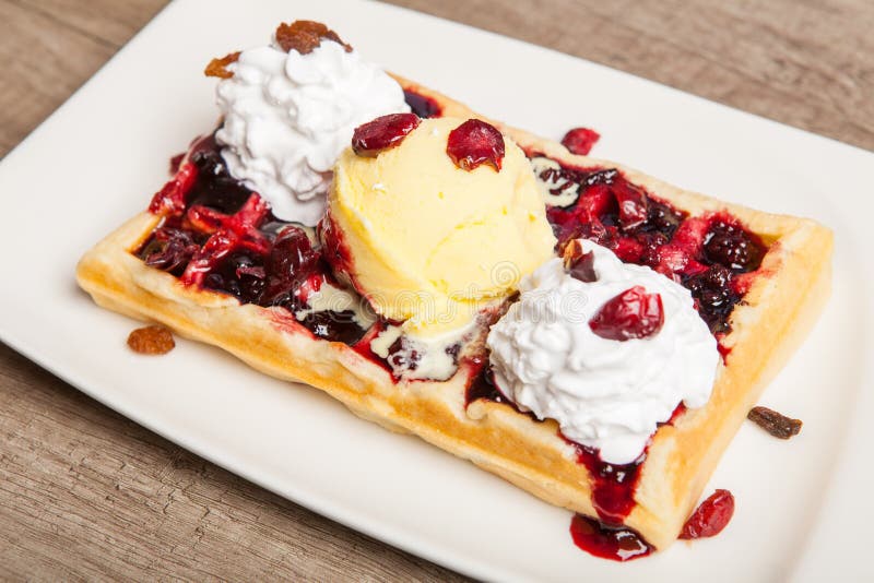 Traditional Belgian waffles with ice cream and berry fruit sauce