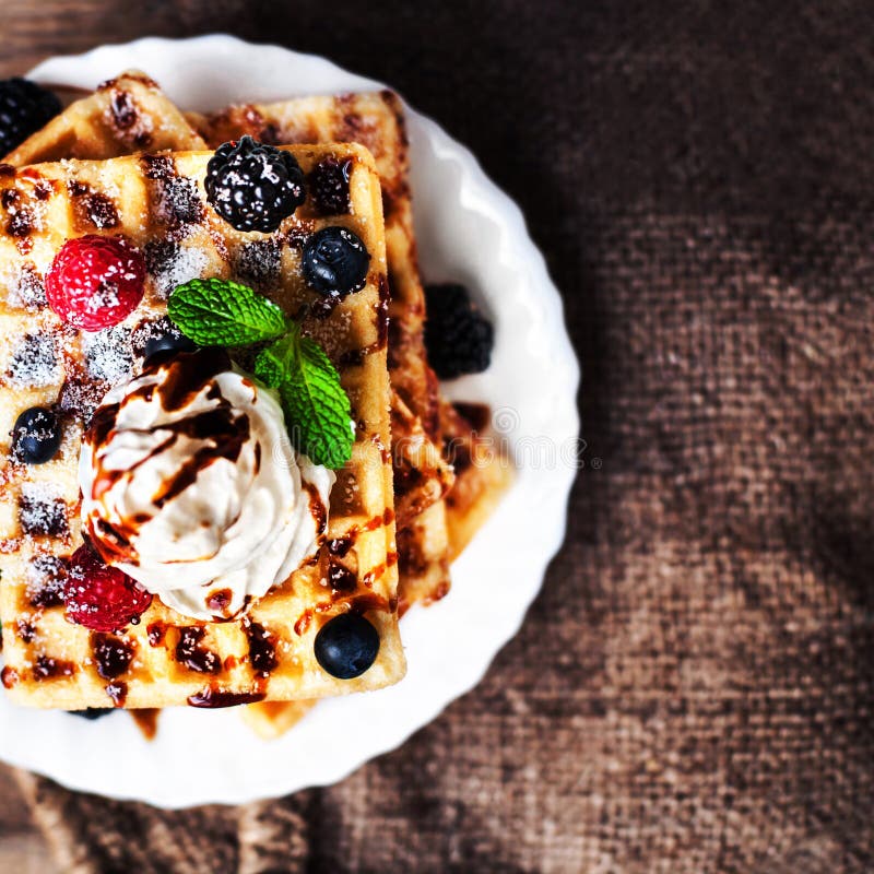 Traditional Belgian waffles with ice cream and berry fruits on