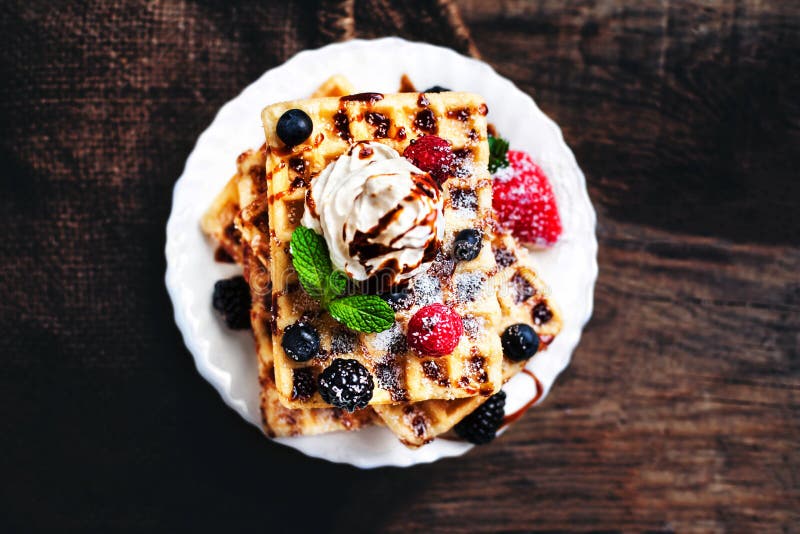 Traditional Belgian waffles with ice cream and berry fruits on