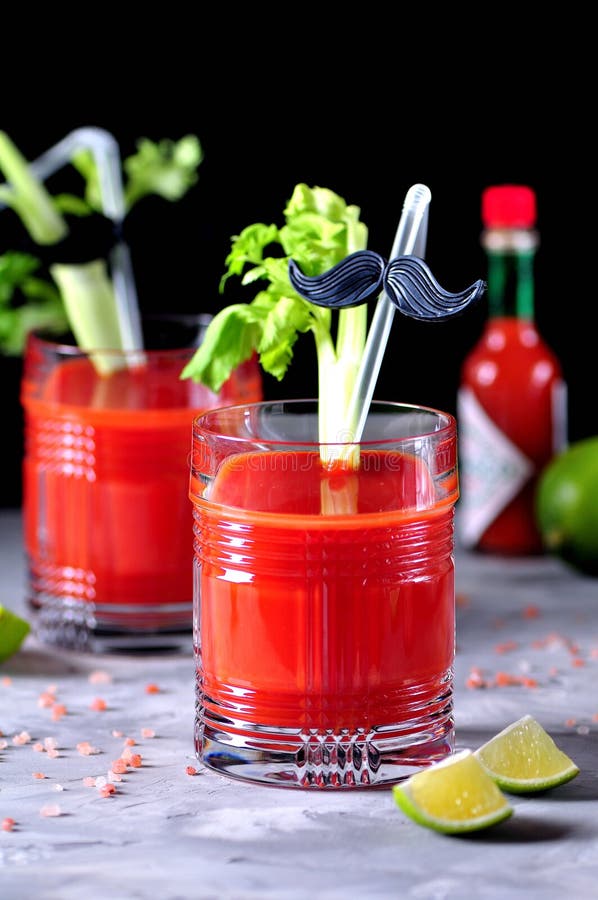 Bloody Mary cocktail in glasses-skull with celery sticks, pink salt, lime  and canapes from canned vegetables. Stock Photo by ©chudo2307 146601963