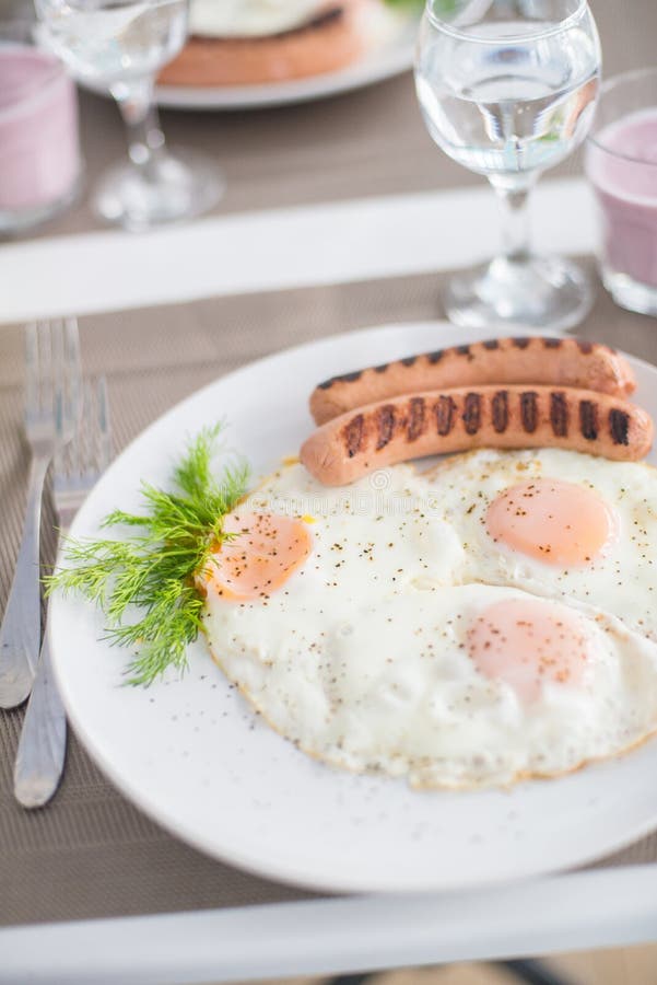 Traditional breakfast with sausages, fried eggs with ground black pepper and bread royalty free stock photography Traditional breakfast with sausages, fried eggs with ground black pepper and bread royalty free stock photography