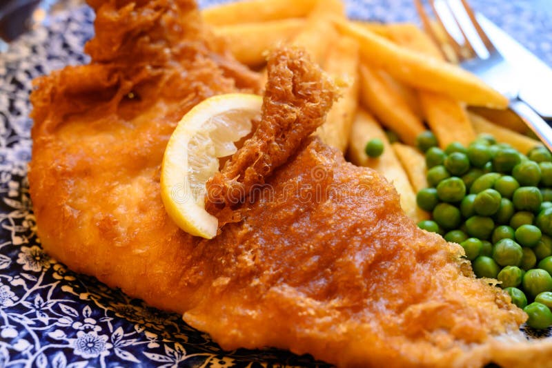 Traditional British food fish and chips served with green peas