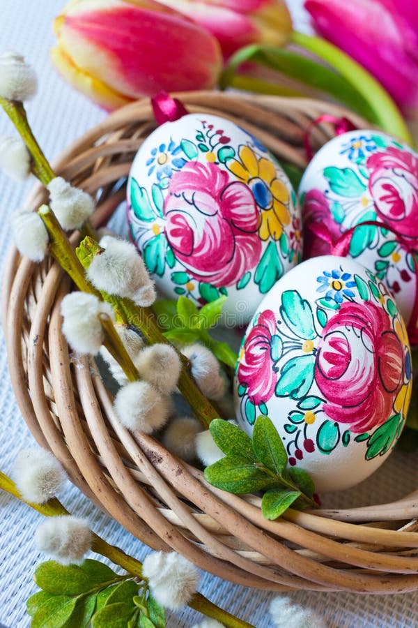 Traditional Czech easter decoration - colorful painted eggs in wicker nest with pussycats