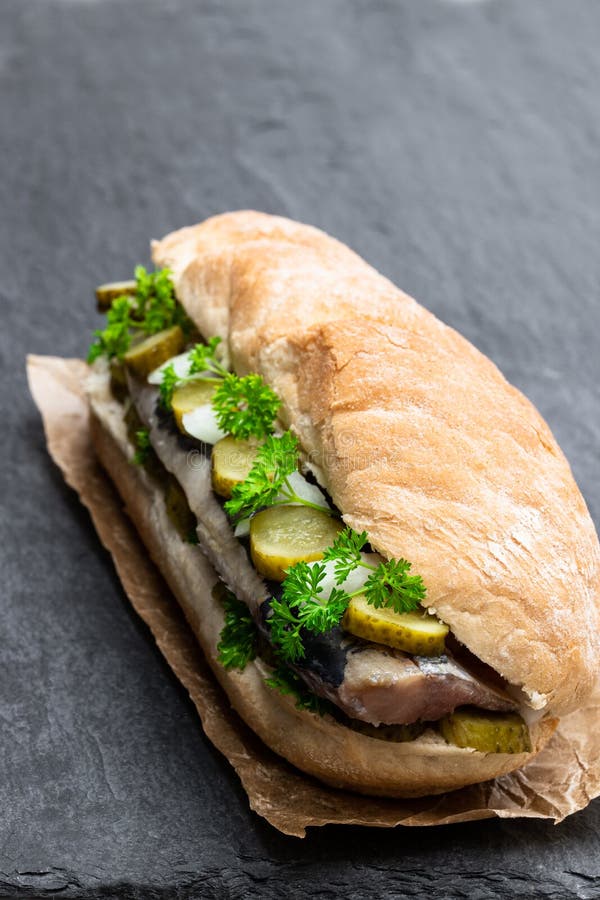 Traditional Dutch Sandwich with Herring and Pickles on Black Stone