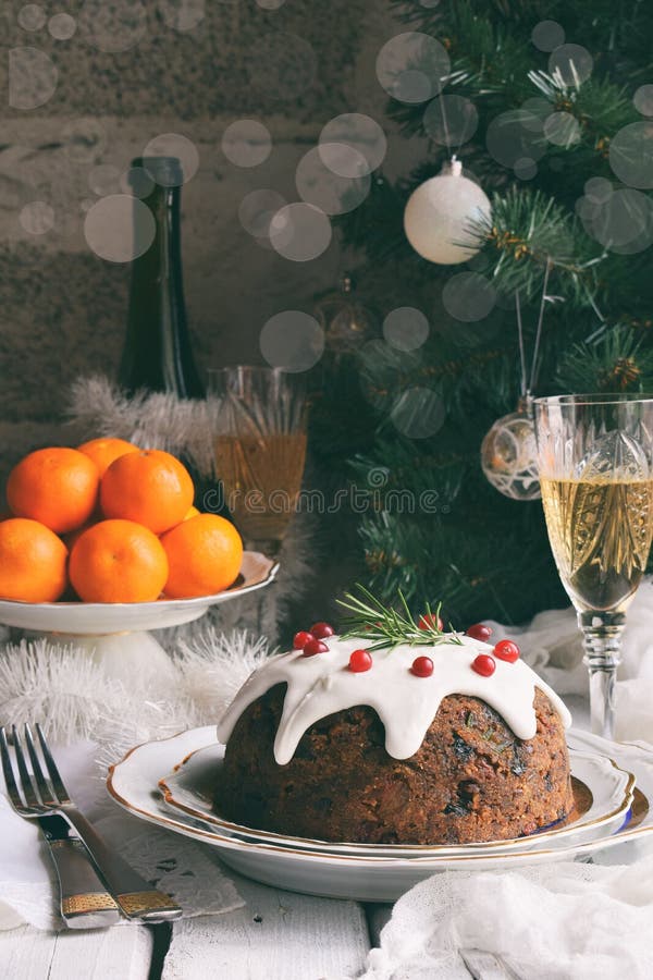 Traditional english Christmas steamed pudding with winter berries, dried fruits, nut in festive setting with Xmas tree, tangerines stock photo Traditional english Christmas steamed pudding with winter berries, dried fruits, nut in festive setting with Xmas tree, tangerines stock photo