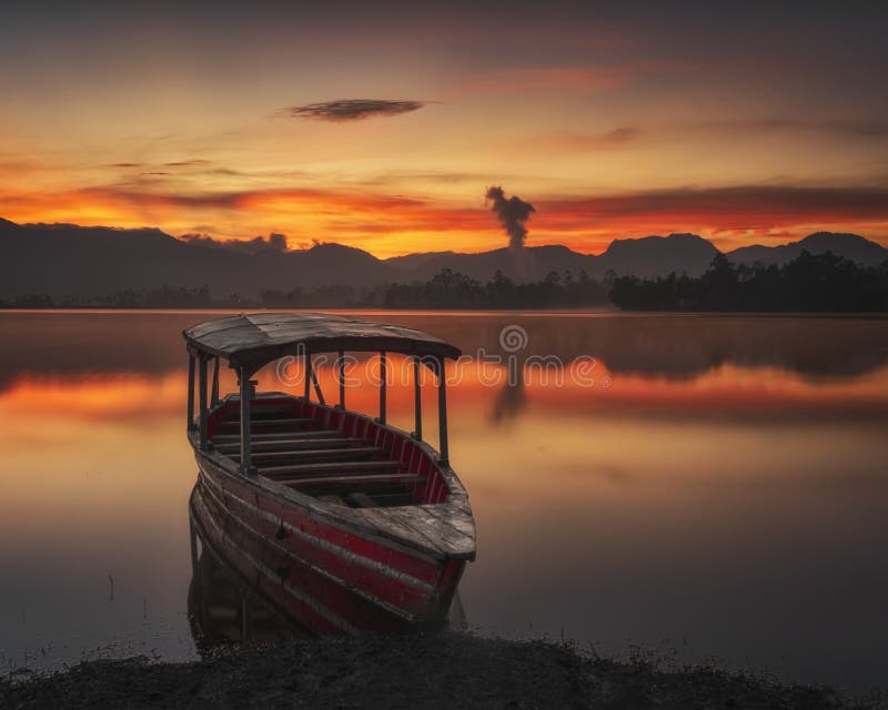 Traditional Fishing Boat on the lake when the sky is tinted by the rising sun