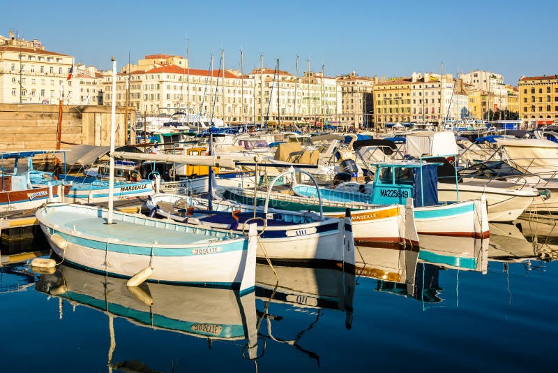 Traditional fishing boats moored in the Old Port of Marseille, France, at sunset