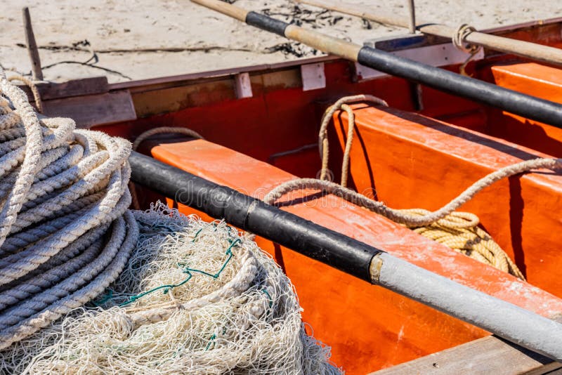 Traditional Fishing Net on Small Rowing Boat on Beach Stock Photo