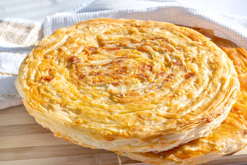 Traditional homemade Tajik Fatir (layered flat bread) with cheese and onion on light wooden background royalty free stock image Traditional homemade Tajik Fatir (layered flat bread) with cheese and onion on light wooden background royalty free stock image