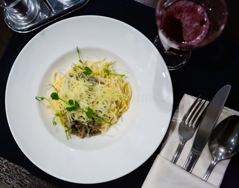 Italian Creamy Mushroom Pasta with Cheese Garnished with Microgreens