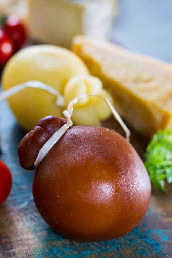 Traditional Italian hard cheese Provolone of Caciocavallo smoked and white on wooden background. Traditional Italian hard cheese Provolone of Caciocavallo smoked and white on wooden background