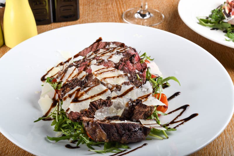Traditional Italian Main Dish. Beef Tagliata Tender Beef Rib Eye, Arugula, Cherry Tomatoes