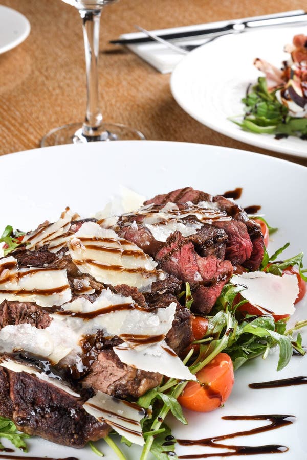 Traditional Italian Main Dish. Beef Tagliata Tender Beef Rib Eye, Arugula, Cherry Tomatoes