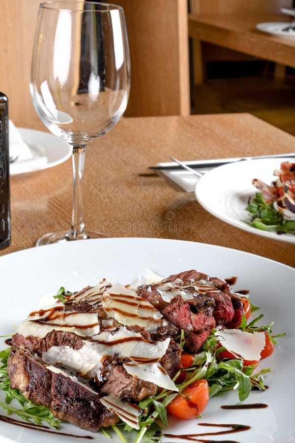 Traditional Italian Main Dish. Beef Tagliata Tender Beef Rib Eye, Arugula, Cherry Tomatoes