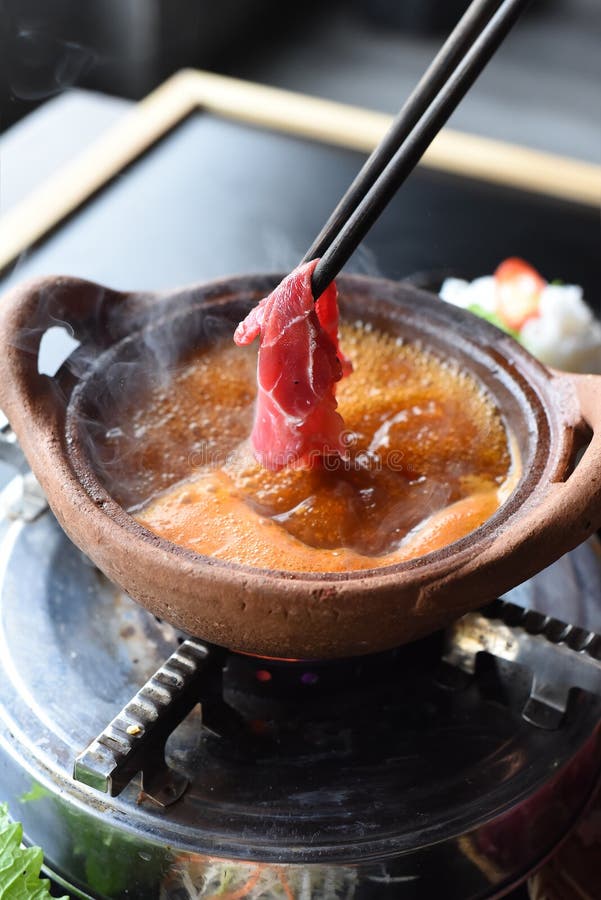 Traditional Korean Hot Pot Dish with Beef and Spicy Bouillon on Black