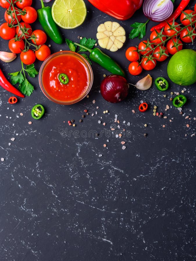 Traditional Mexican Latin American salsa sauce and ingredients on black stone table. Top view copy space