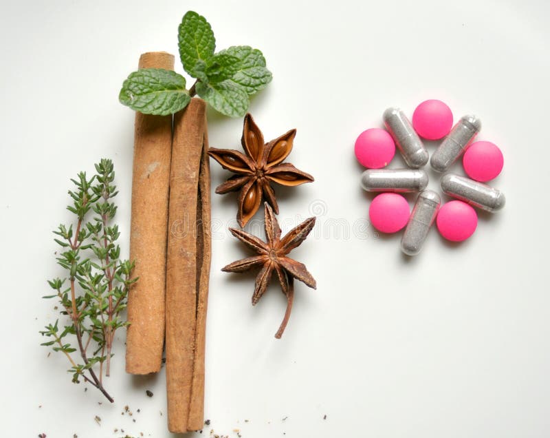 Natural remedy versus modern medicine : various leaves with pills. Mint leaf, cinammon, thyme, anice star, garlic versus pink pill. choose natural substance over chemical product. Green herbal drug medicine stock images, royalty-free photos and pictures