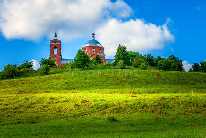 Traditional old Russian Church - summer landscape with blue sky, green hills with grass stock images Traditional old Russian Church - summer landscape with blue sky, green hills with grass stock images