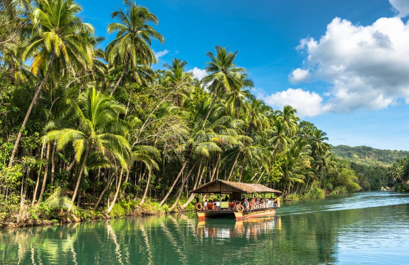 Traditional raft boat with tourists on a jungle green river