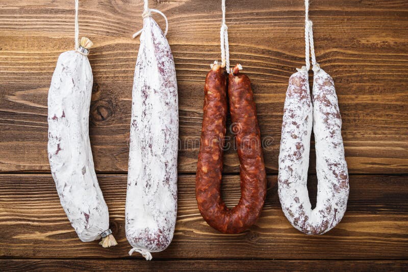 Traditional spanish smoked sausages meat hanging on wood table