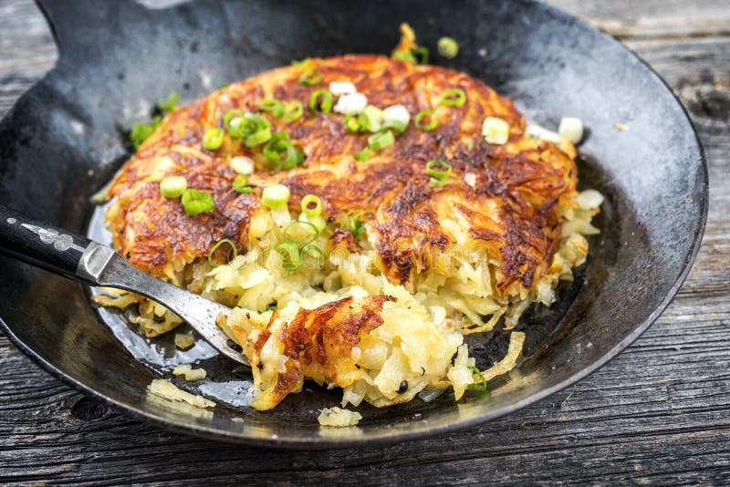 Traditional Swiss hash browns as side dish with leek in a wrought-iron frying pan