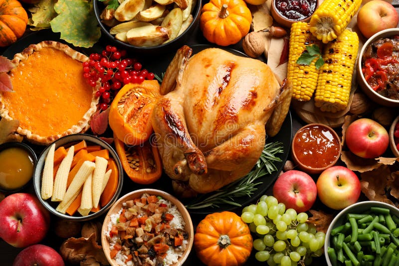 Traditional Thanksgiving day feast with delicious cooked turkey and other seasonal dishes as background, top view