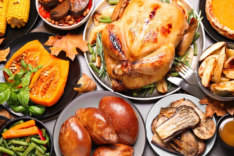 Traditional Thanksgiving day feast with delicious cooked turkey and other seasonal dishes served on grey table, flat lay. Traditional Thanksgiving day feast with