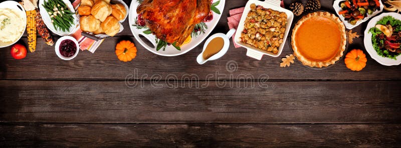 Traditional Thanksgiving turkey dinner. Above view top border on a dark wood banner background.