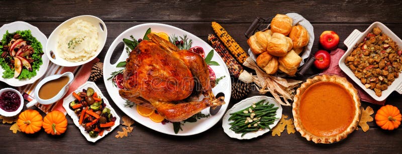 Traditional Thanksgiving turkey dinner. Top view table scene on a dark wood banner background.