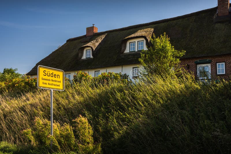 Traditional thatched-roof house and town sign on Nordstrand peninsula