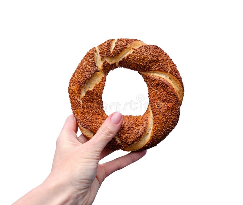 Traditional Turkish bagel simit in female hand isolated on white background stock photography