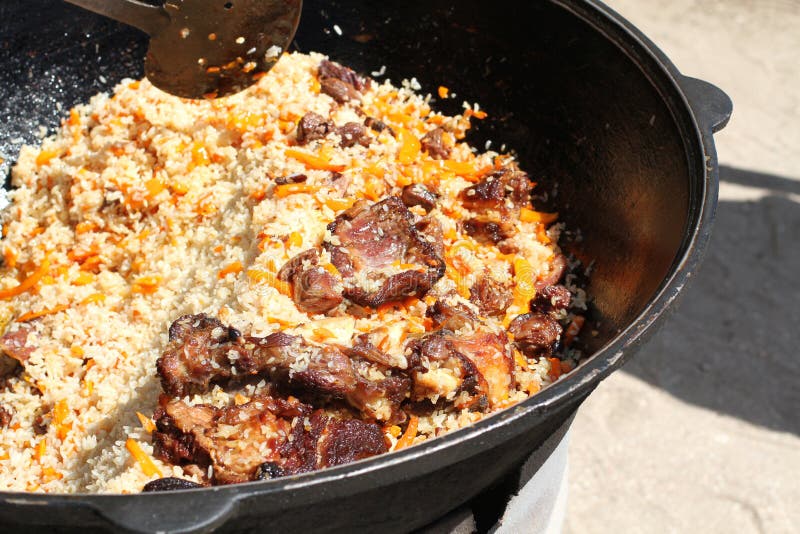 Lamb in a Large Castiron Cauldron on Fire. Pilaf Cooking Process Stock